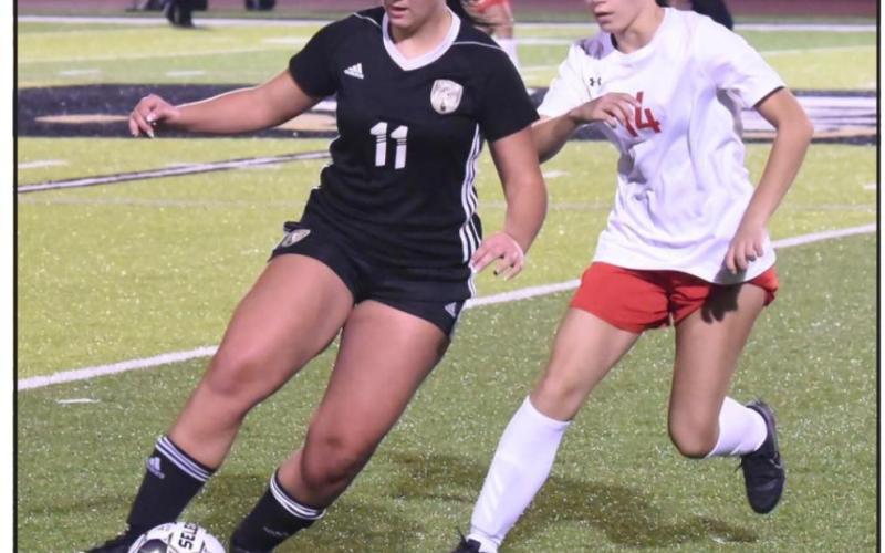 Lady Pirate Angelia Arledge maneuvers the ball past a Cleveland defender. Photo by Randall Luker