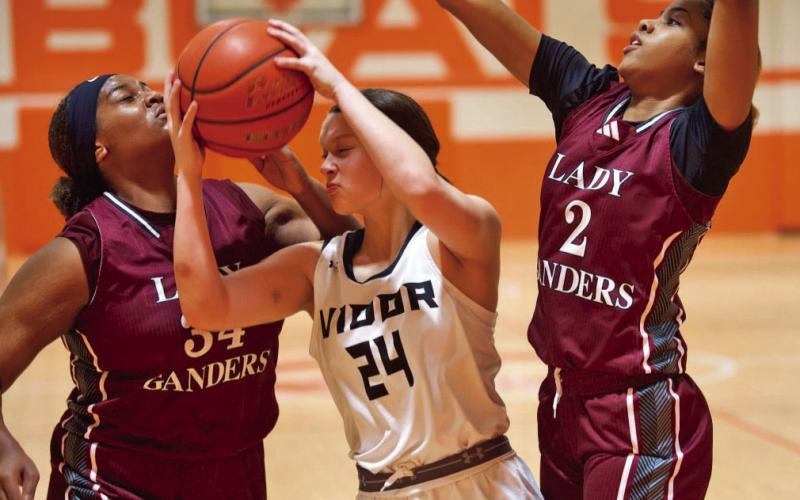 Guard that ball Madison Perkins pulls down a rebound while surrounded by Baytown Lady Ganders.