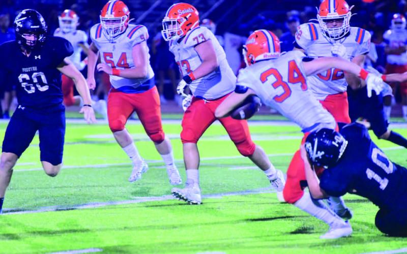 Keaton Abshire pulls down a Saints runner as Hayden Garrett moves in to assist. Photo by Randall Luker