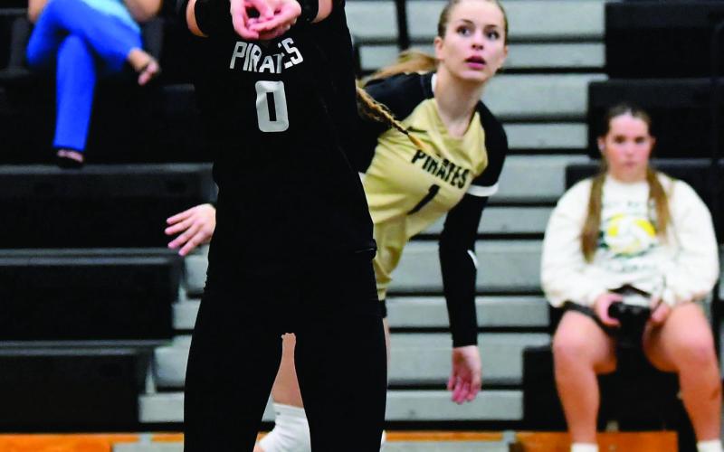 Loghan Matherne sets the ball for Makena Travis in Friday’s home game versus LCM.