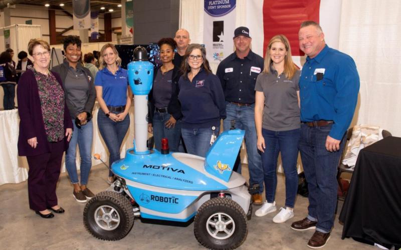 Platinum sponsor Industry of Southeast Texas representatives showcase robotic equipment used for student demonstrations.