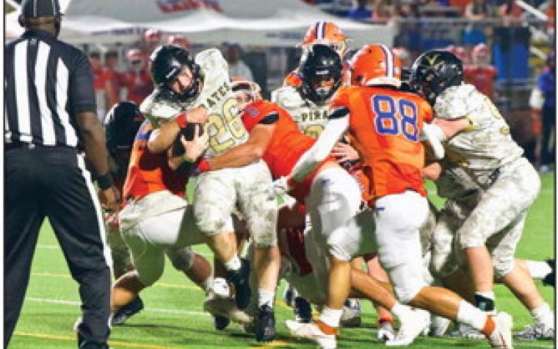 Pirate RB Riley Marlow fights for extra yardage as a pair of Saints defenders try to bring him down. Photo by Randall Luker