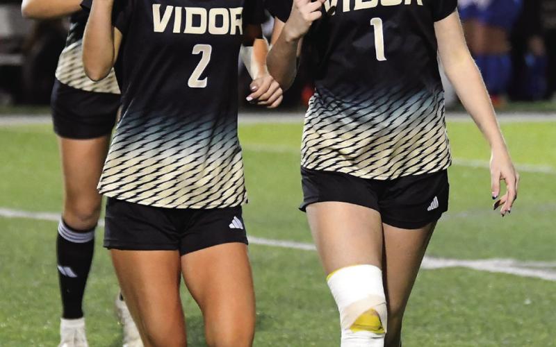 Taylor and Jordin Bull throw their V’s up as they come off the field after pre-game warmups.