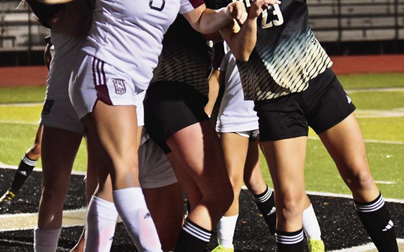 Laikynn Jones grimaces as Pirates and Tigers use their heads to send the ball in their preferred direction.