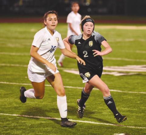 Lady Pirate Sabrey Eaves races a Blackcat for possession in last Tuesday’s playoff game in Santa Fe.
