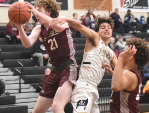 Varsity Pirate Aiden Ochoa fights for possession under the net.