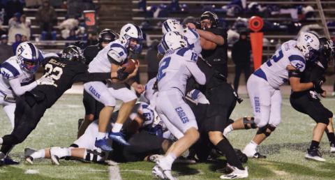 Aidan Villafano reaches for Eagle QB Clint Thurman as he jumps through the line. Photo by Randall Luker