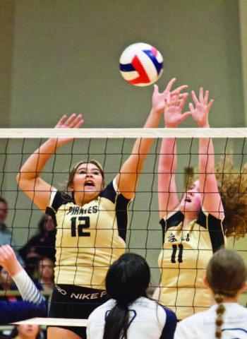 Lady Pirates Laikyn Brodnax #12 and Rylee Sherman #11 jump for a block in Tuesday’s playoff game versus the Lady Hawks. Photo by Randall Luker
