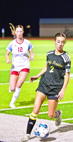 Hugging the sideline Taylor Bull moves the ball into Lady Raider territory in Tuesday night’s district game with Lumberton.