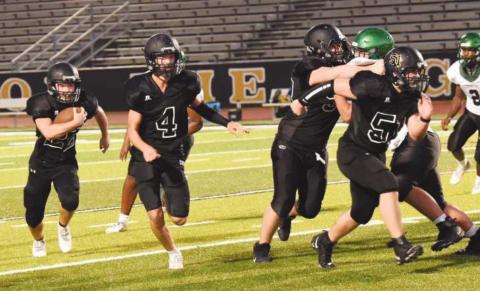 JV RB Caleb Dean bursts out of the backfield as #4 Ricky Gall, #50 Brooklyn Freeman, and #51 Jesse Meyers get out front to block.