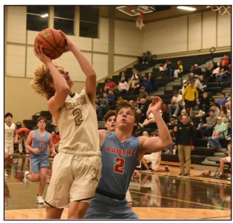 Junior varsity Pirate Brody Wright out jumps a Raider to shoot. Photo by Randall Luker