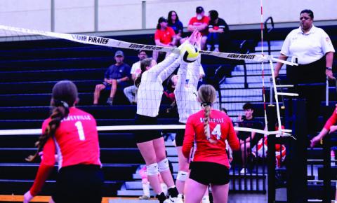 Madison Powell, left center, and Brilie Cornelison, tight center/ block a Deweyville return and score for The Lady Pirates Friday at Pirate gym. All three Vidor Lady Pirate teams defeated Deweyville in straight sets. Photo by Randall Luker