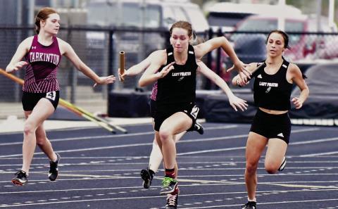 Lady Pirate Jana Baters, far right, hands off the baton to Miley Rice in the 4X100m relay at the Gid Campbell Relays held in Anahuac Thursday. Photo by Randall Luker