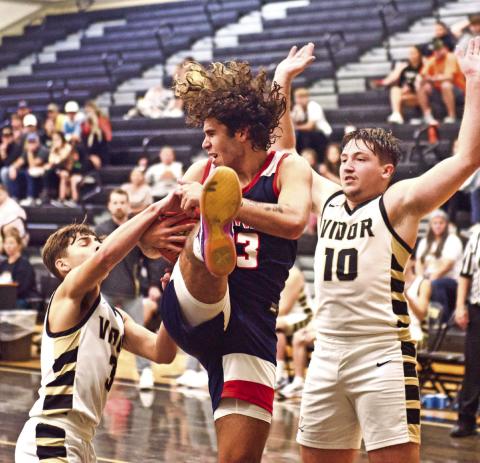 Battle under the basket Pirates Jose Guerrero-Evans, #3, and Camden Young, #10, battle a Hardin-Jefferson player for a rebound Monday at Pirate Gym.