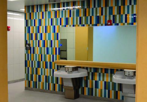 Modern lavoratories, colorful tiles, mirrors and open spaces highlight the restrooms at Oak Forst Elementary which will open to the student population january 9. Photo by Randall Luker