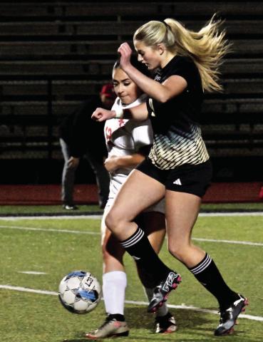 Quincy LaPray maintains control of the ball as a Lady Cardinal looks for a steal.