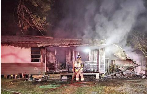 Smoldering remains An Orange County ESD#1 firefighter knocks down hotspots at a home in the 900 block of Pin Oak where two children were rescued by Vidor Police Officers by forcing a window air conditioner inside the home and pulling the children out the window. The cause of the fire was ruled accidental.