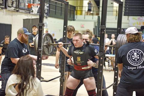 It’s a cinch Lady Pirate Layla Robinson gets a hand with her equipment as she belts up for the bench press at the Nederland High School Powerlifting meet Friday.