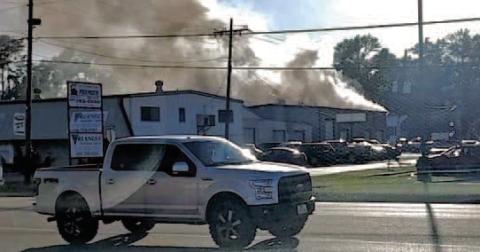 Billowing clouds of smoke pour from the C and R Transmission shop on Garland Street Tuesday after a lithium ion battery caught fire and spread through the building.
