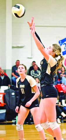 Madison Guillot sets the ball as Madison Powell readies for the return in Tuesday ’s bi-district playoff game in Anahuac.