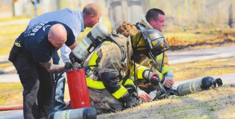 Firefighters with the OCESD#1 have their equipment checked after fighting a structure fire Monday.