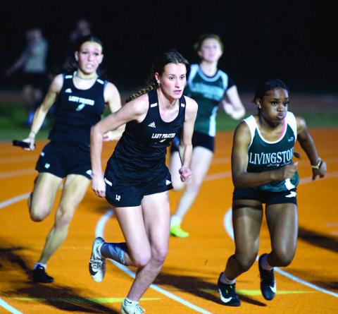 Jaden Lee, front, and Naomi Collier, rear, prepare to handoff in the 4X100 relay event. Photo by Randall Luker