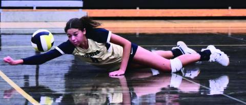 Lady Pirate Kenya Correia goes to the floor as she attempts a dive and dig versus the Lady Horns. Photo by Randall Luker