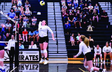 Rylee Sherman takes to the air for a return as Natalie Morrison runs toward the net. Photos by Randall Luker