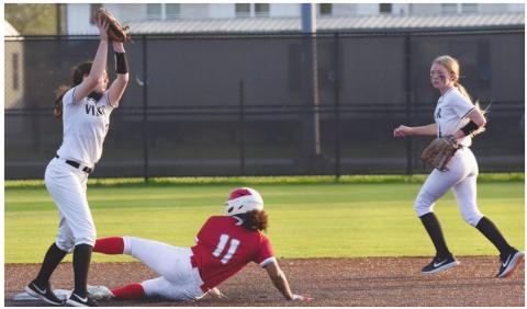 Lady Pirate shortstop Brilie Cornelison reaches for the throw as a Lady Cardinal slides into second base. Second baseman Gracie Matherne provides backup.