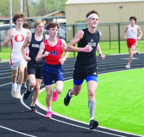 Branson Healy, front, placed 2nd in the 3200 meter run with time of 11:19.50 at the Bridge City relays Thursday. Photo by Randall Luker