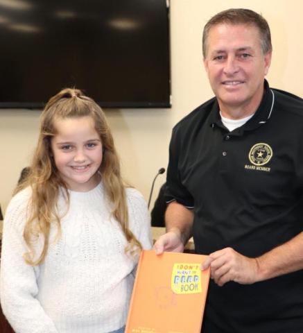 Presenting a book to the Oak Forest library in honor of Mr. David Camp was Jasmyn Smith.