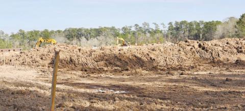 With trackhoes that dug it in the background, this exavation on the northwest corner of the campus was a prerequisite for rebuilding on the Oak Forest Elementary campus. When completed, the detention ponds will capture water runoff before it flows to neighboring properties. As an added bonus, Science classes may also use it as an outdoor lab and observation area.