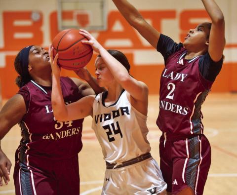 Guard that ball Madison Perkins pulls down a rebound while surrounded by Baytown Lady Ganders.