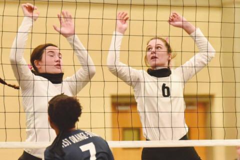Lady Pirates Ava Lightfoot, left, and Brooklyn Bushelle in action at the net in Saturday’s home game versus the Lady Mustangs.
