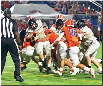 Pirate RB Riley Marlow fights for extra yardage as a pair of Saints defenders try to bring him down. Photo by Randall Luker