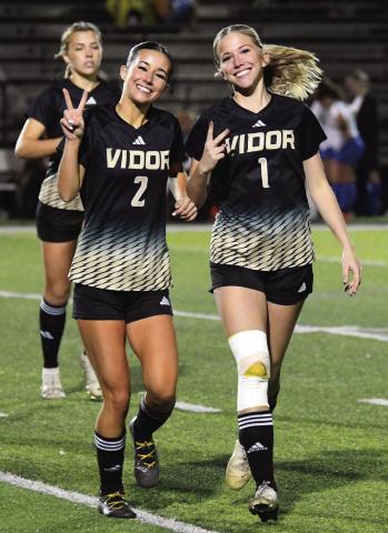 Taylor and Jordin Bull throw their V’s up as they come off the field after pre-game warmups.