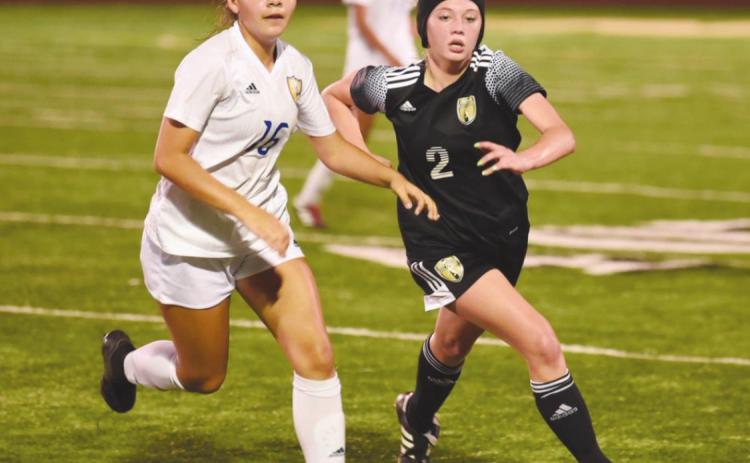 Lady Pirate Sabrey Eaves races a Blackcat for possession in last Tuesday’s playoff game in Santa Fe.