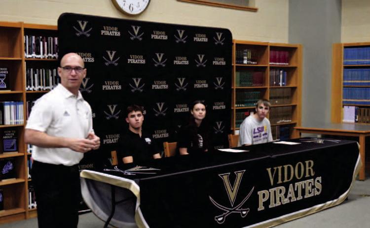 VISD Athletic Director Dwayne DuBois introduces Daigan Venable, Madison Perkins and Caden Williamson at the college signing ceremony held in the VHS Library Friday.
