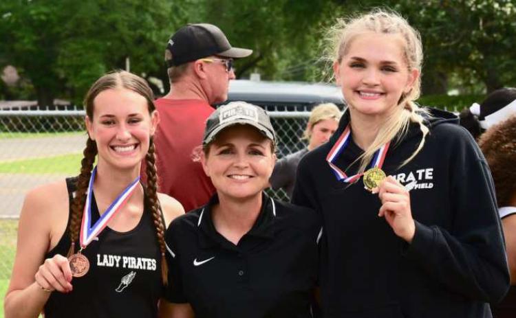 Vidor Head Girls Track Coach Tracy Maines, center, poses with two of Vidor’s district champions, Jaden Lee, left, and Raegan Stephenson, right.