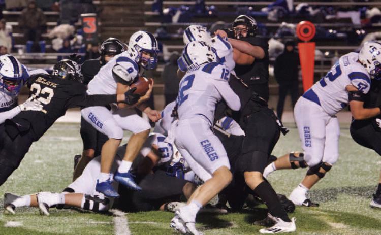 Aidan Villafano reaches for Eagle QB Clint Thurman as he jumps through the line. Photo by Randall Luker