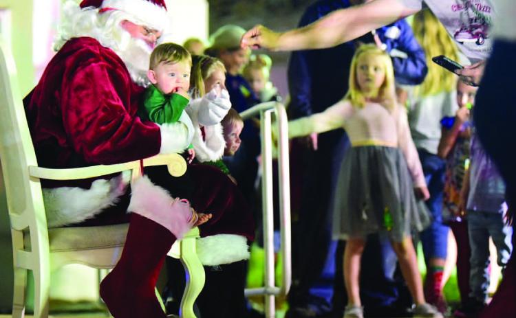 The wonderment of Christmas could be seen in the eyes of children as they lined up to talk to Santa and sit on his lap for a photograph at Vidor City Hall Friday. Photo by Randall Luker