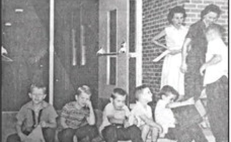 DEJECTION, DISGUST, MIRTH, AND ANTICIPATION, are all expressed on the faces of the youngsters shown in the picture taken on the first day of school at Pine Forest Elementary. According to Mrs. Arlen Portie, principal, registration went well, despite the 'exhausted' looks on the faces of some students shown in the above picture. The only students identified are (l to r) Buddy and Arlos Bennet. (September 10, 1963 issue)