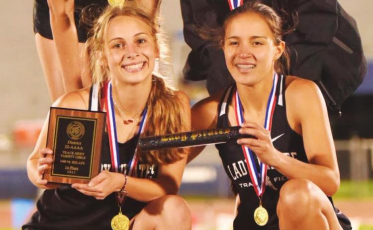Mile Relay District champs-Lady Pirates Raegan Stephenson, Amelia Wright, Jana Baters and Sofia Rodriguez pose on the podium following their first place finish in the district track meet last week.