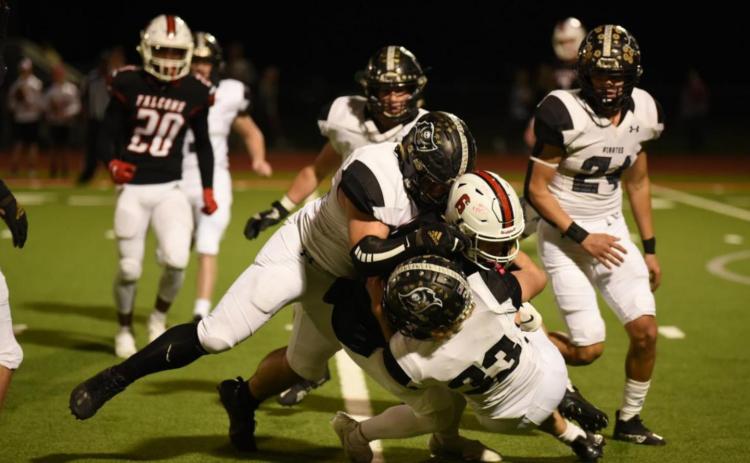Jordan Smith and Connor McKay, #33, wrap up a Falcon ball carrier for a loss of yardage. Photo by Randall Luker