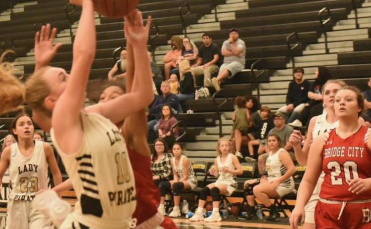A Bridge City Lady Cardinal fouls Natalie Morrison as she goes for two. Photo by Randall Luker