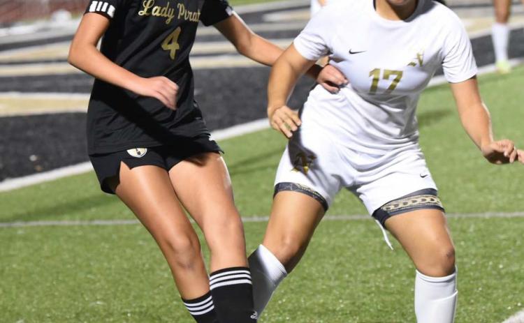Lady Pirate Kenya Correia maneuvers the ball near the sideline as a Lady Bulldog competes for possession. Photo by Randall Luker