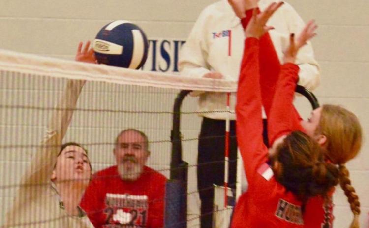 Lady Pirate Brilie Cornelison attempts a return over the outstretched arms of two Lady Falcon defenders. Photo by Randall Luker