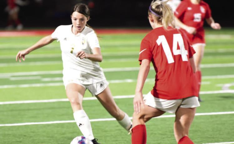 Chloe Post maneuvers past a Lady Cardinal as she approaches the goal in Friday’s varsity district match in Bridge City. Photo by Randall Luker