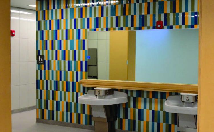 Modern lavoratories, colorful tiles, mirrors and open spaces highlight the restrooms at Oak Forst Elementary which will open to the student population january 9. Photo by Randall Luker