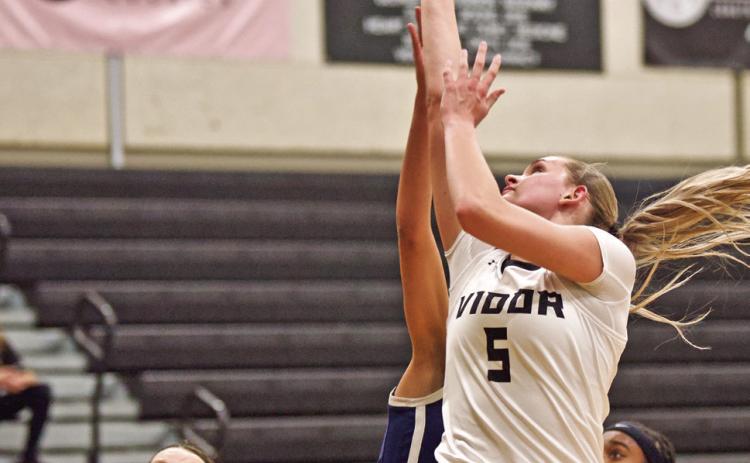 Vidor’s Raegan Stephenson shoots from under the basket in Friday’s 62-48 district win over the WOS Lady Mustangs as. Madison Perkins watches for the rebound.